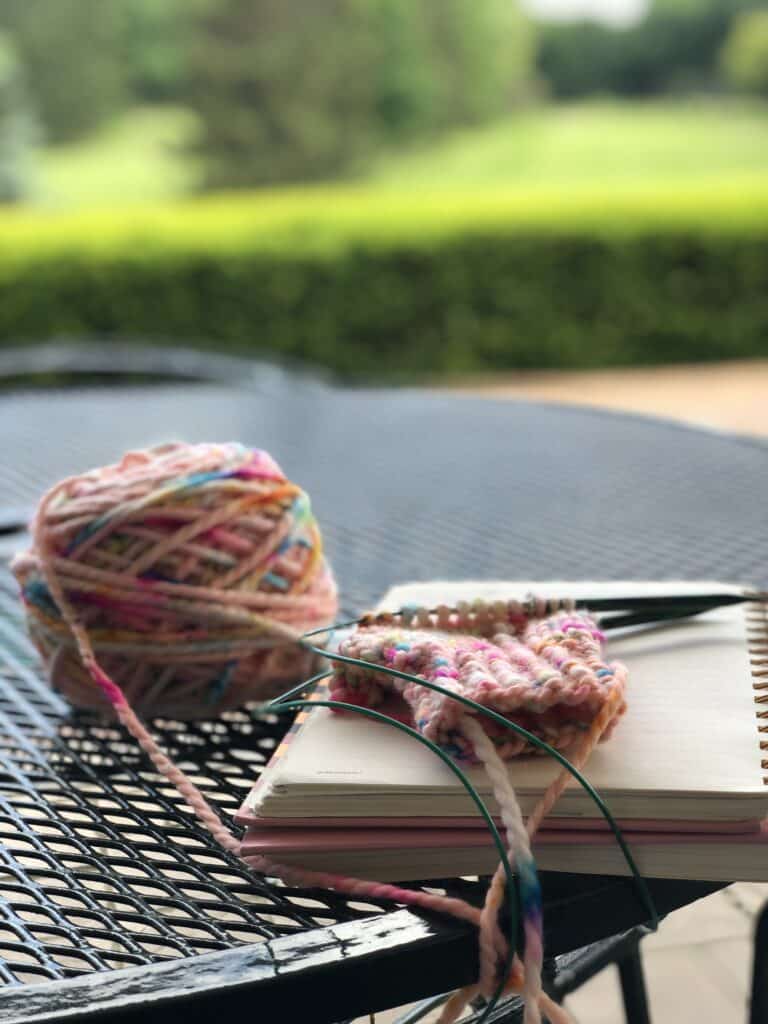 Knitting pattern writing while kids are golfing.