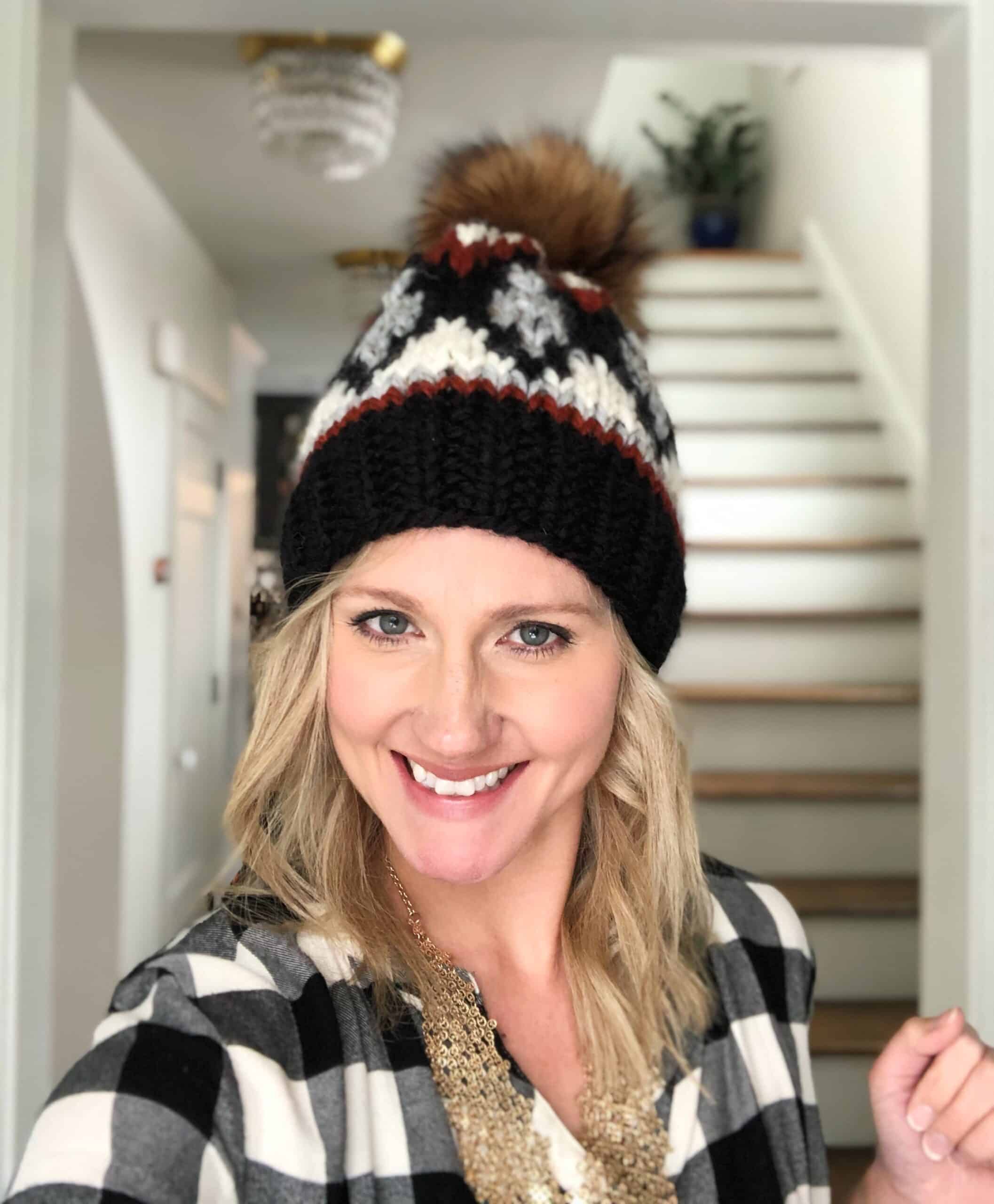 Woman wearing the Glimmer Beanie, a super bulky diamond colorwork hat knitting pattern with faux fur pom.