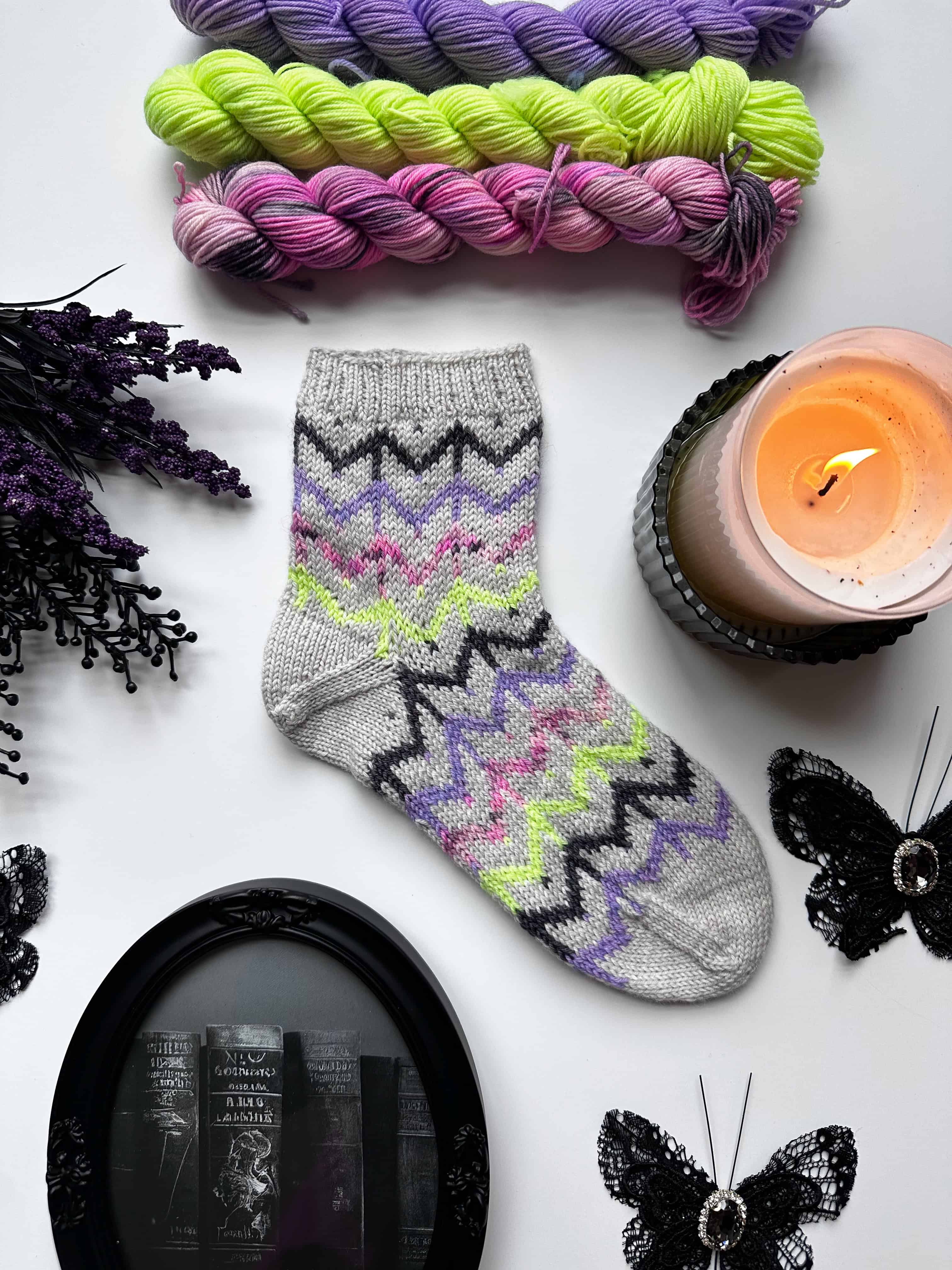Finished Whispering Webs colorwork socks featuring colorful spider web motifs