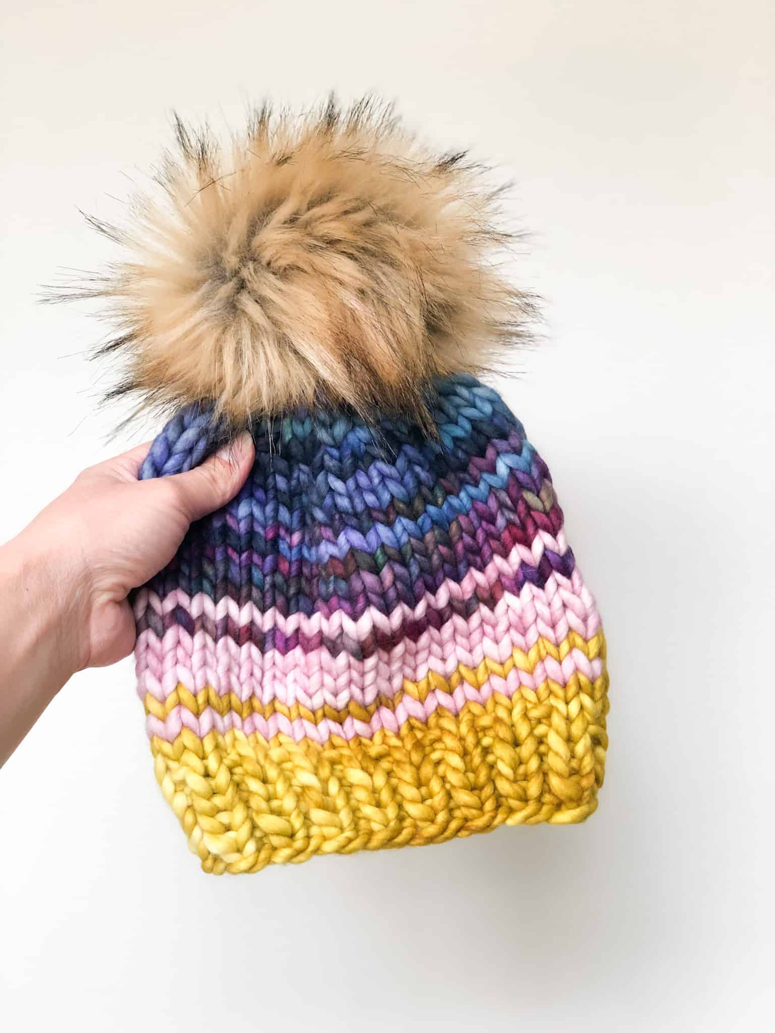 Close-up of a colorful striped Snippet Beanie knit in four shades of super bulky yarn